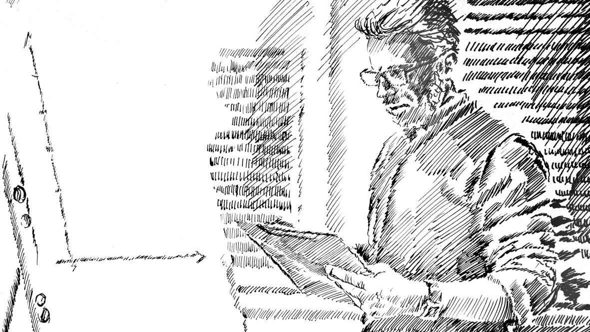 A man is standing in front of a flipchart, looking thoughtfully at a pad of paper in his hand.